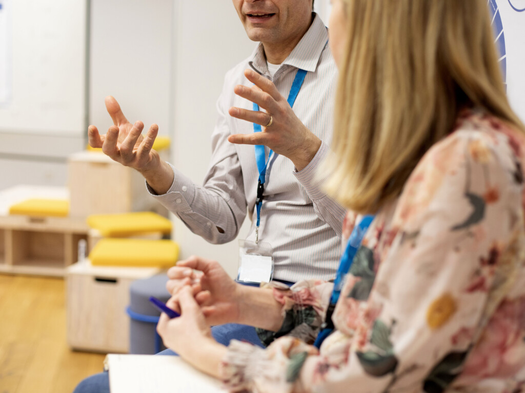 Teilnehmende im Coaching-Gespräch, Hände und Gestik betonen den Austausch.